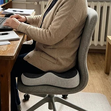 Kobieta siedzi prosto na poduszce